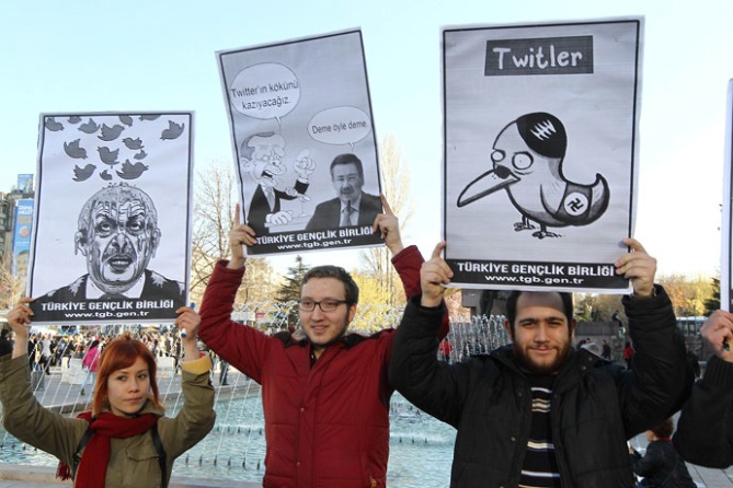 People in Turkey hold placards as they protest against Turkey's Prime Minister after the government of Turkey blocked access to Microblogging platformTwitter